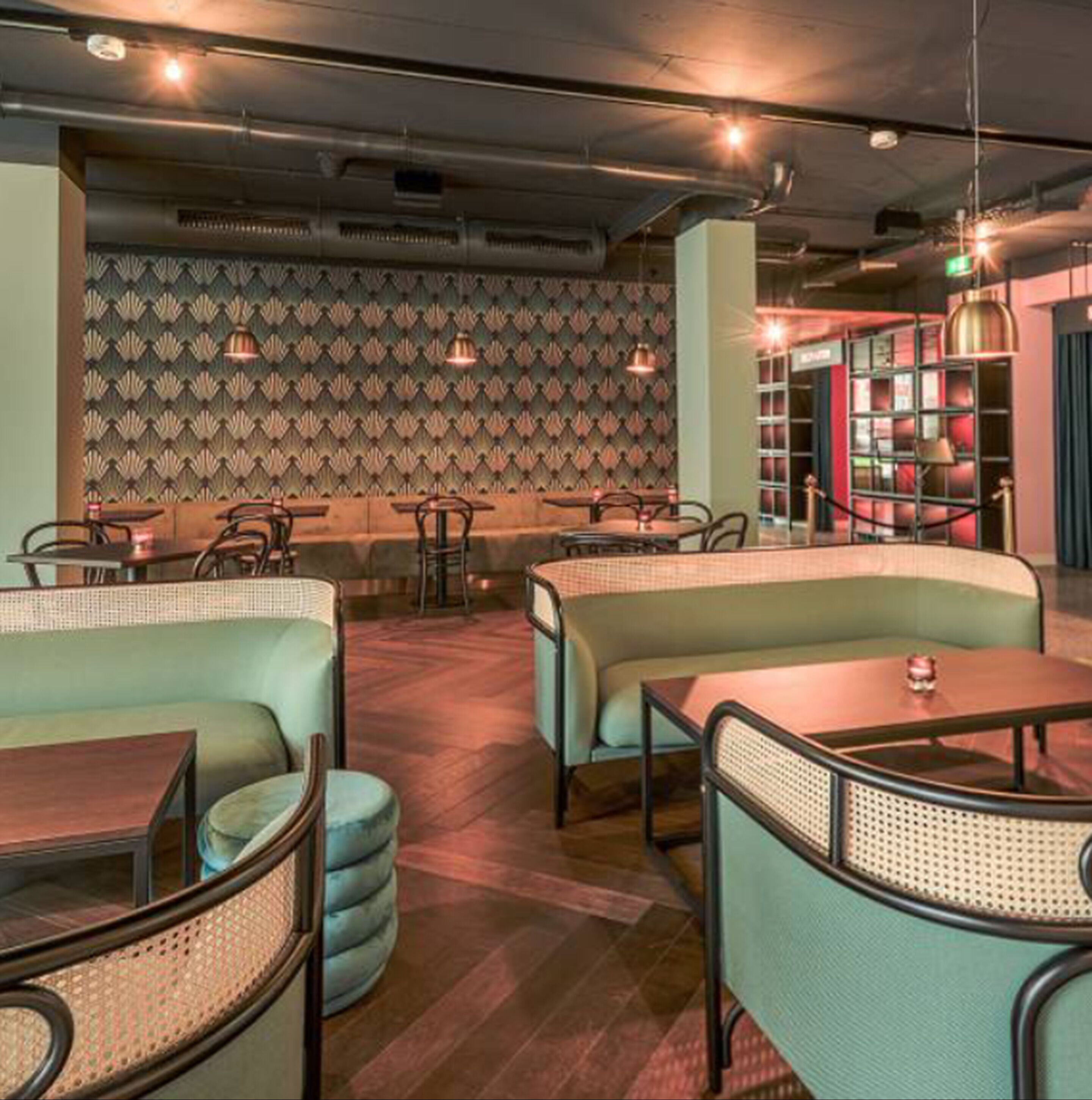 A restaurant interior with booths, tables, and a patterned wall.