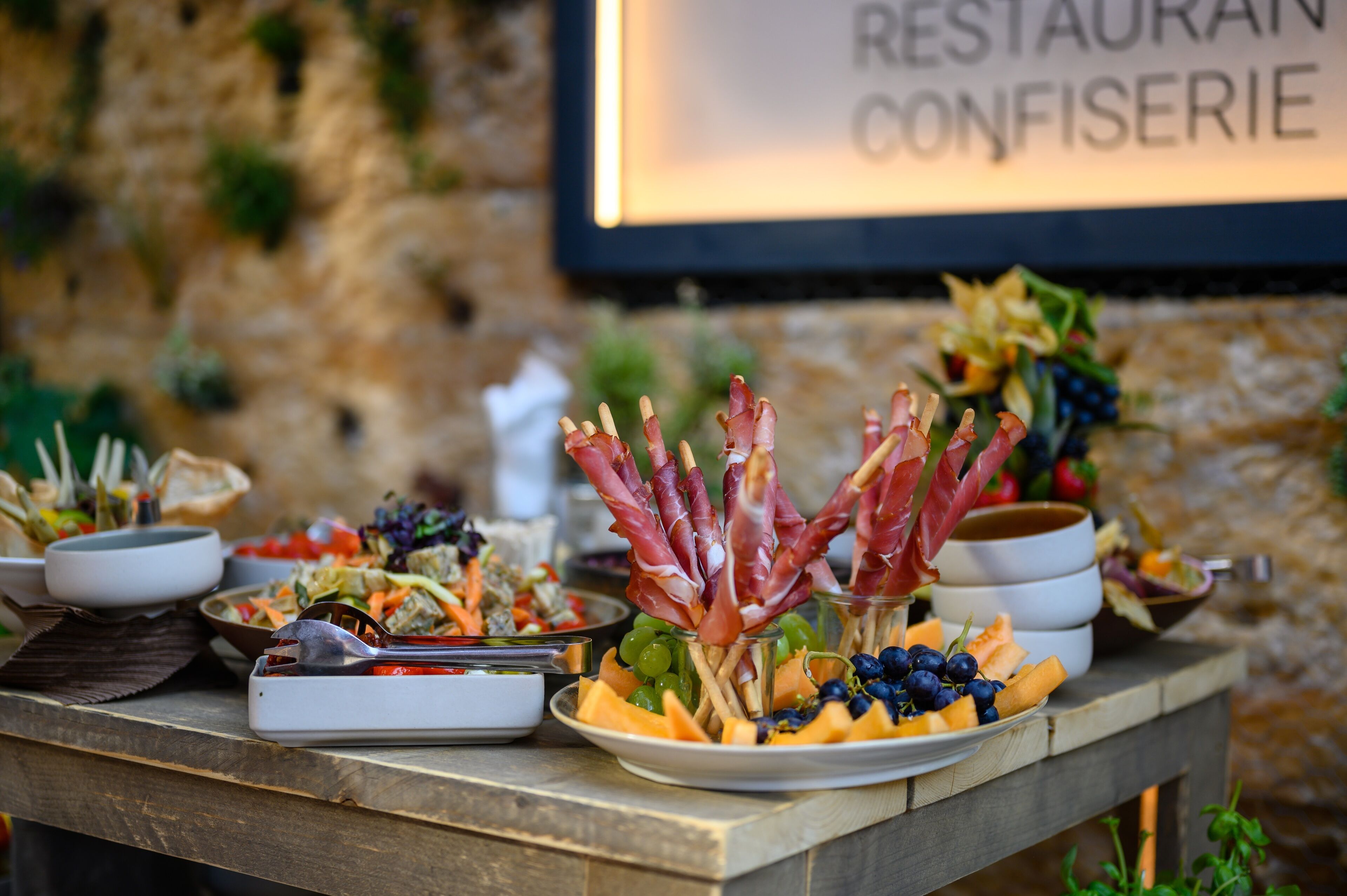 A table with various food items including grapes, melon, and meat skewers.