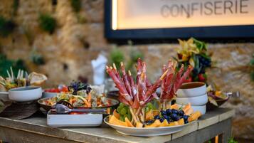 A table with various food items including grapes, melon, and meat skewers.