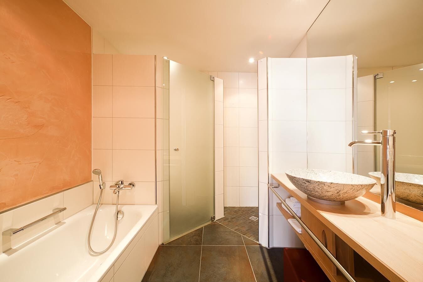 A modern bathroom with a freestanding bathtub, a large mirror, and a bowl sink.