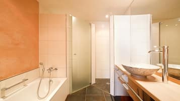 A modern bathroom with a freestanding bathtub, a large mirror, and a bowl sink.