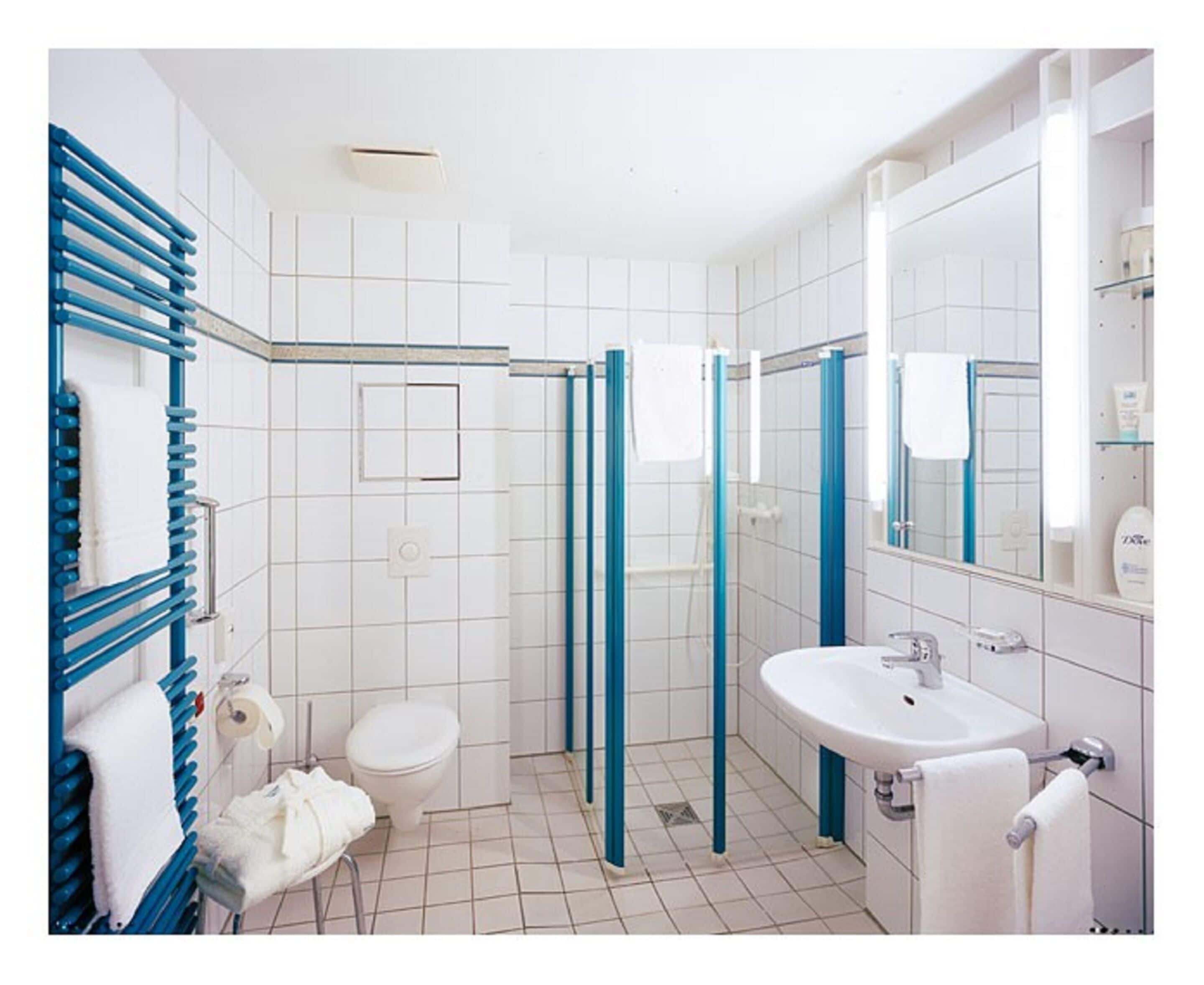 Ein Badezimmer mit Toilette, Waschbecken und Duschbereich.