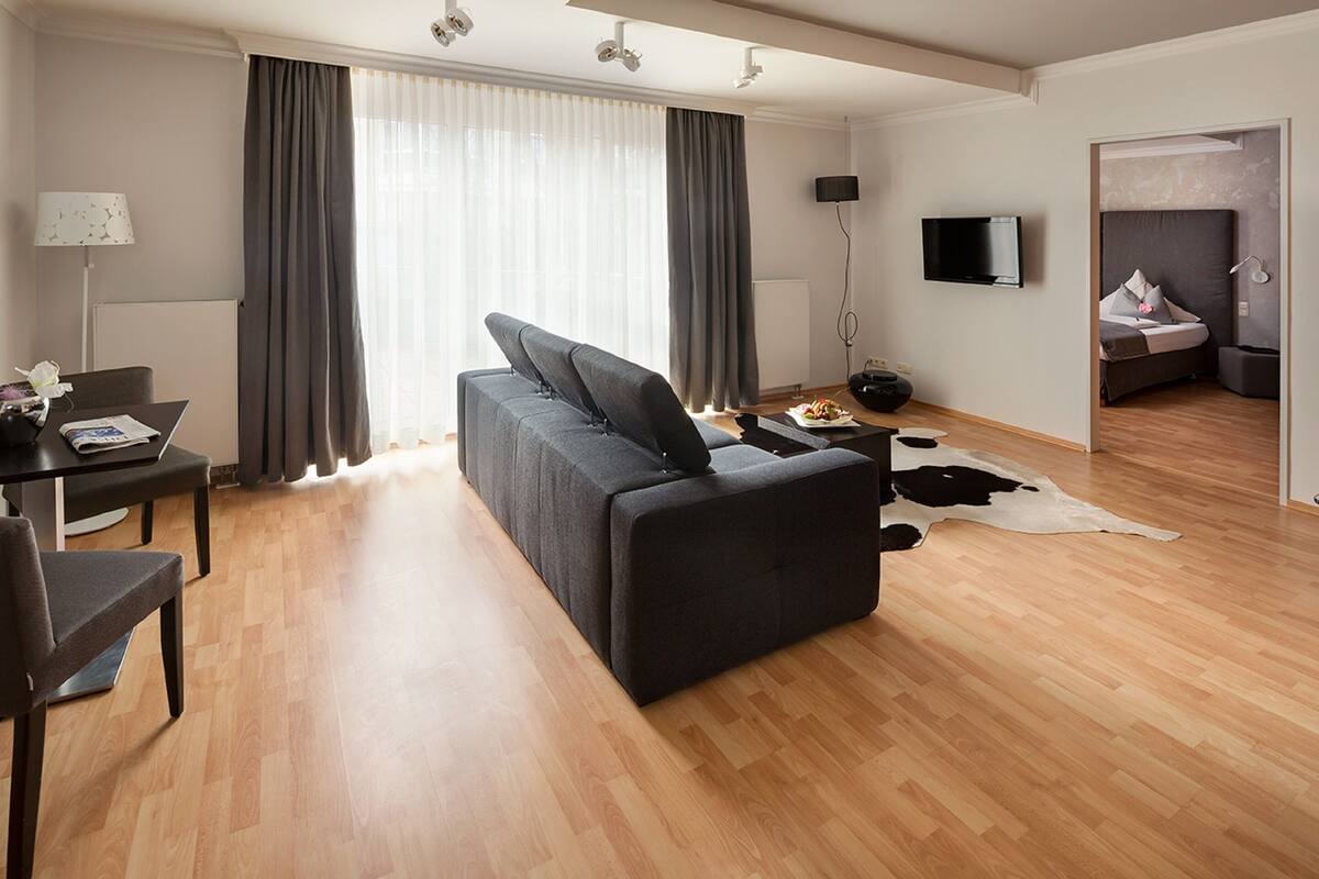 Un salon moderne avec un canapé, une table à manger et un téléviseur.