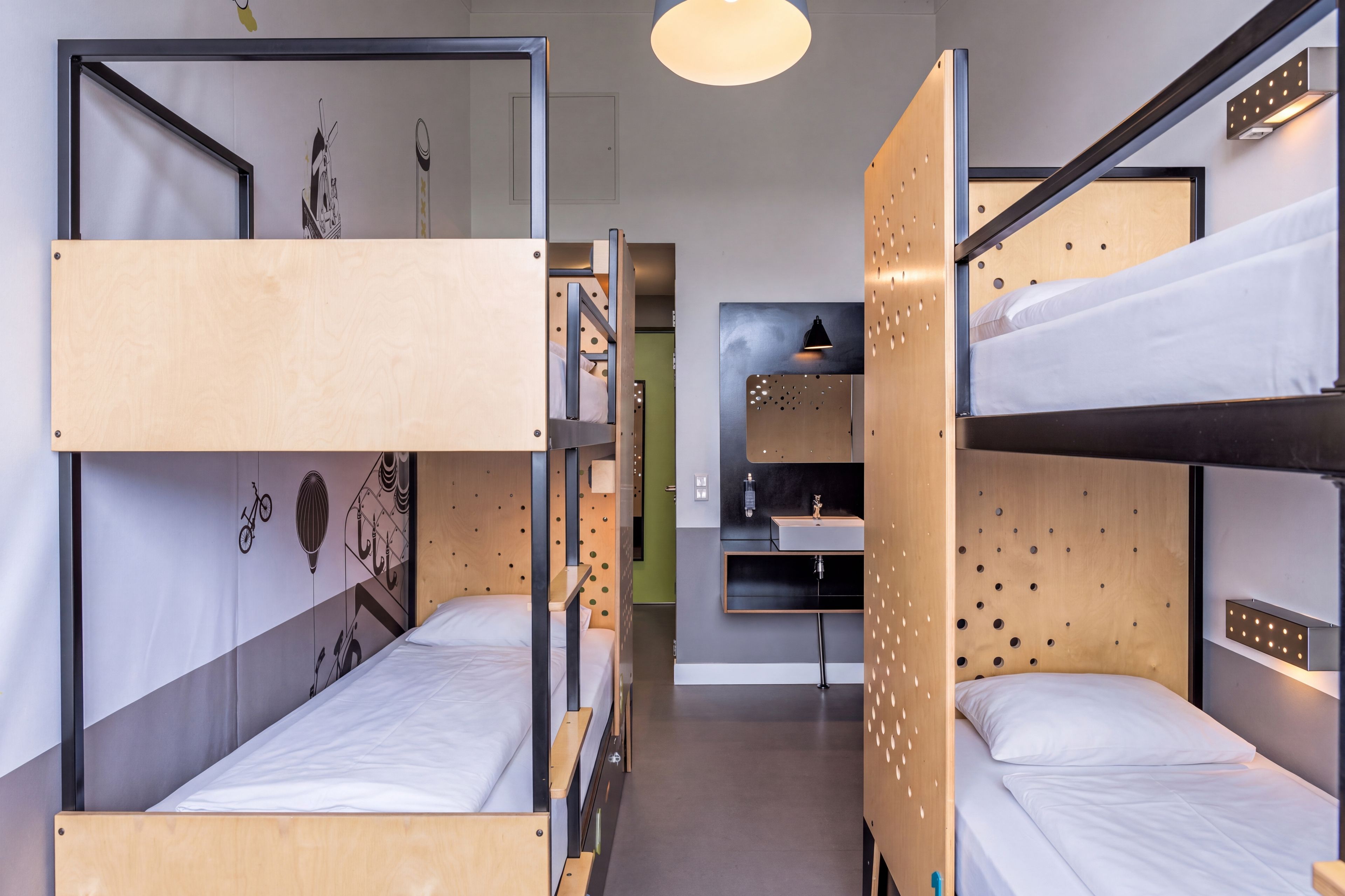A bunk bed room with a desk and a wall-mounted shelf.