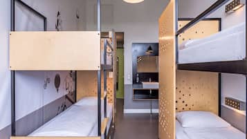 Une chambre avec un lit superposé, un bureau et une étagère fixée au mur.