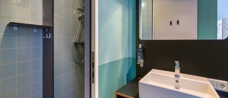 A modern bathroom with a shower, a sink, and a mirror.