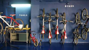 Una habitación con bicicletas colgadas en la pared y una sobre un atril.