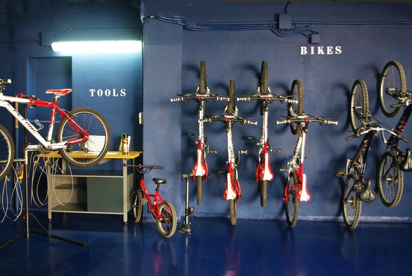 A room with bicycles mounted on the wall and a bike on a stand. - Hotel Terramar (Palafrugell)