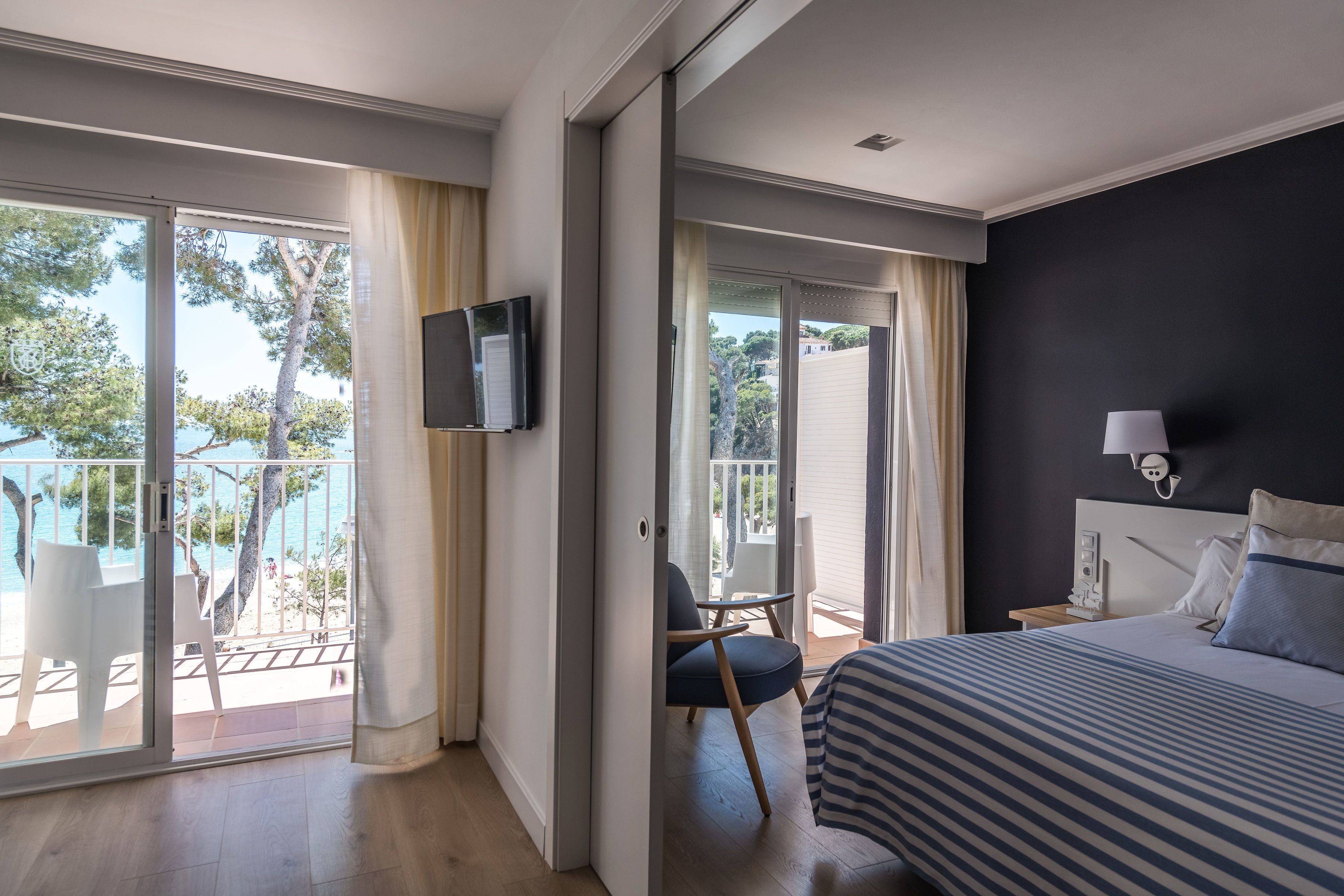 A hotel room with a bed, a TV, a nightstand, and a chair.