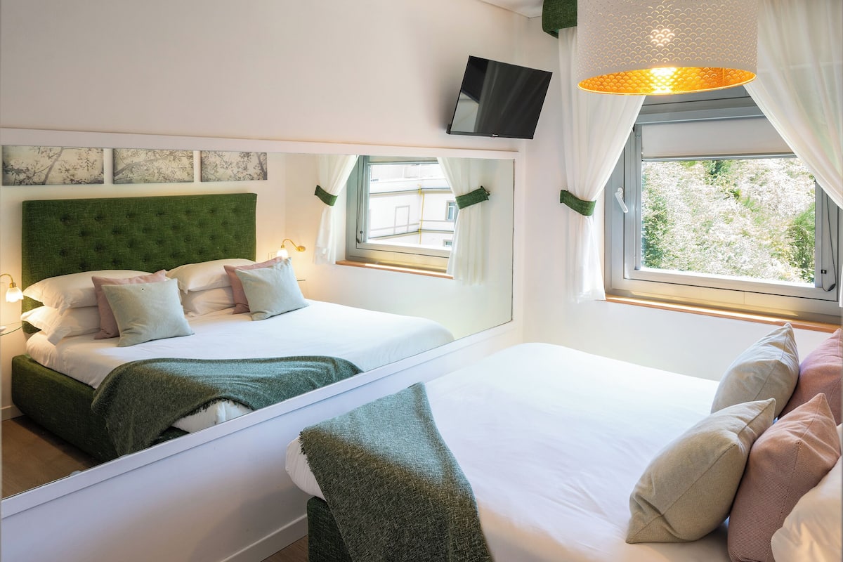 Superior vierpersoonskamer | Donzen dekbedden, een minibar, een kluis op de kamer, een bureau