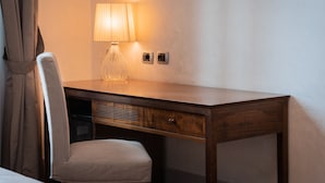 A wooden desk with a lamp, a chair, and two electrical outlets on the wall. - Il Salotto di Firenze (Florence)