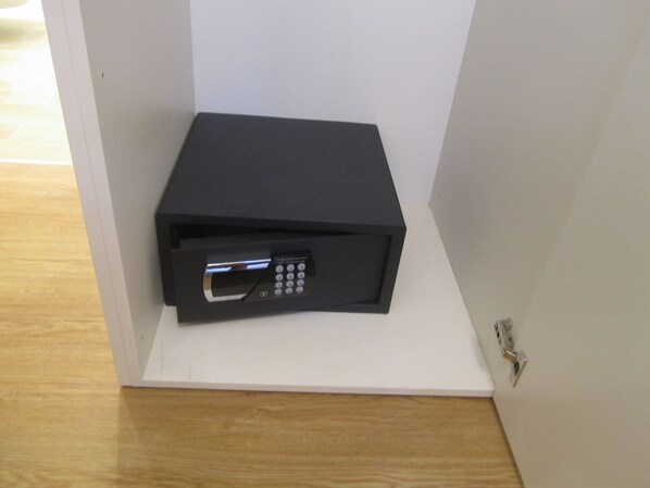 A black electronic device on a white shelf in a room with wooden flooring.