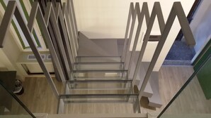A modern staircase with glass railings and wooden steps. - Hotel Borgovico (Como)