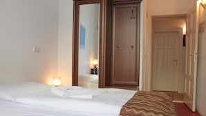 Una habitación de hotel con cama, armario, espejo y puerta.
