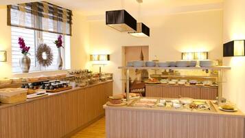 Buffet montado com diversos alimentos e uma grinalda decorativa na janela.