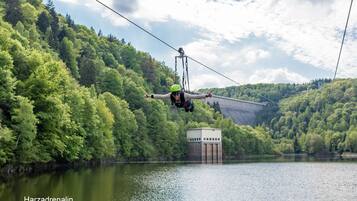A cable car system over a lake with a forested hillside in the background.