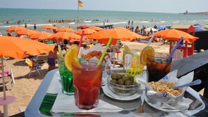 Ett bord vid stranden med drycker, snacks och utsikt över havet.