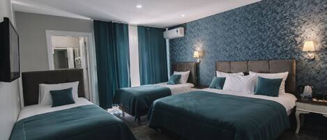 Une chambre d’hôtel avec deux lits, une table de chevet, une lampe et un climatiseur fixé au mur.