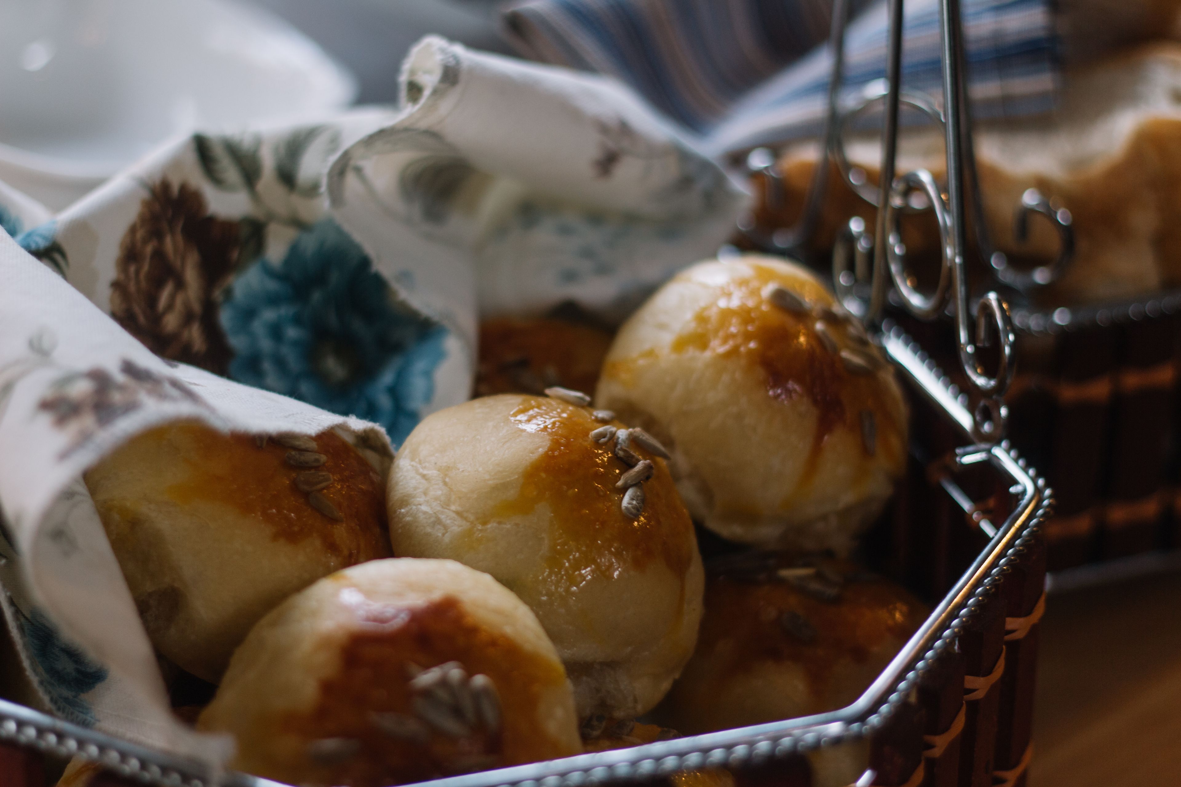 A basket of round, glazed pastries with a cloth.