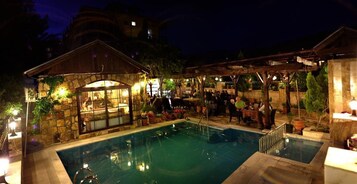 Una piscina al aire libre de temporada, sombrillas
