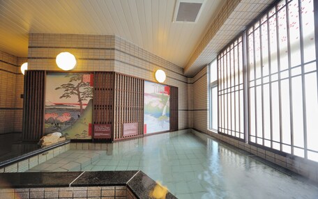 A spacious indoor area with tiled flooring, large windows, and traditional Japanese artwork.