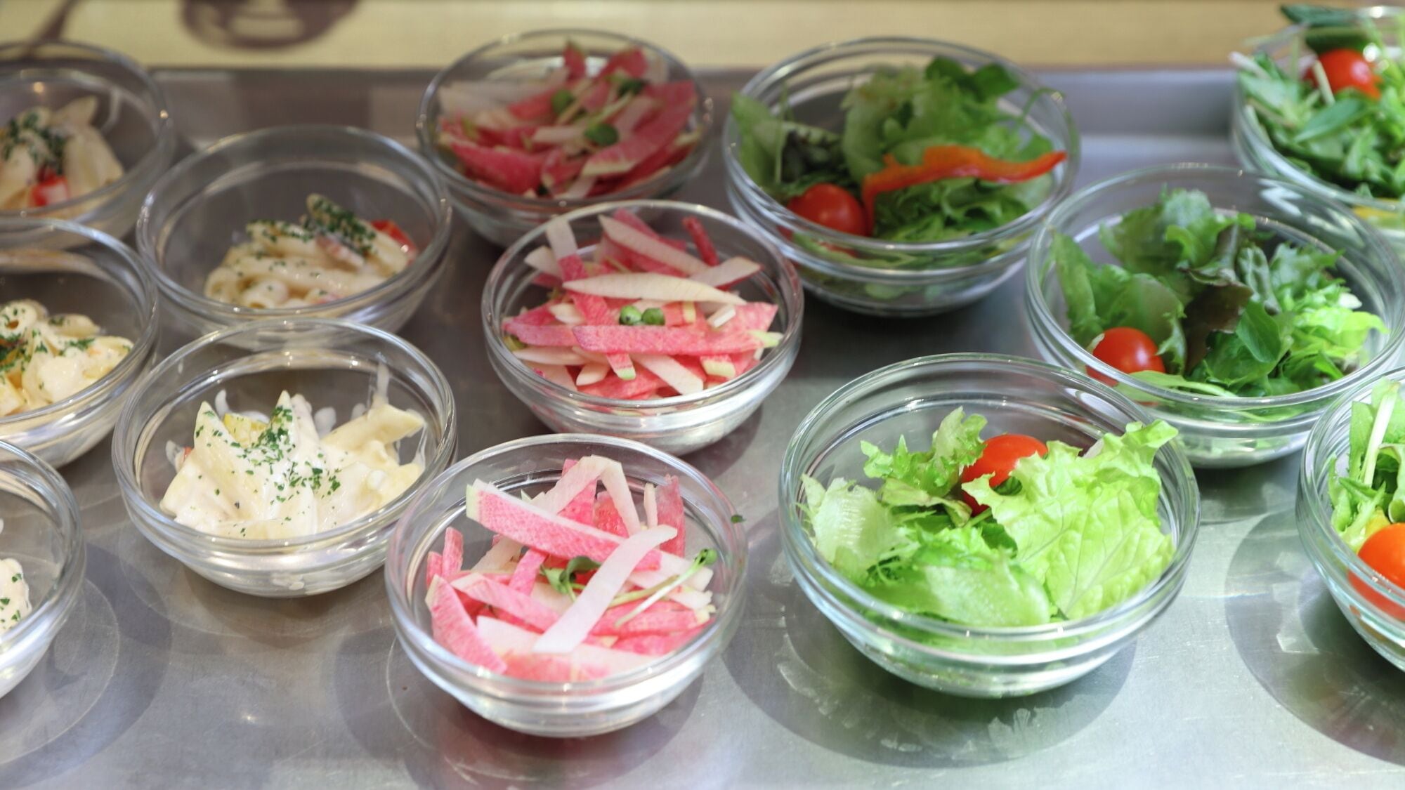 A variety of salad bowls on a metal surface.