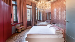 A spacious bedroom with a large bed, a sitting area with a bathtub, and a view of the city through large windows. - Il sogno di Giulietta e Romeo (Venice)