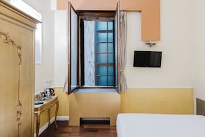 Relax in this cozy retreat with a comfortable bed, a flat-screen TV, and a window offering a view of the outside.