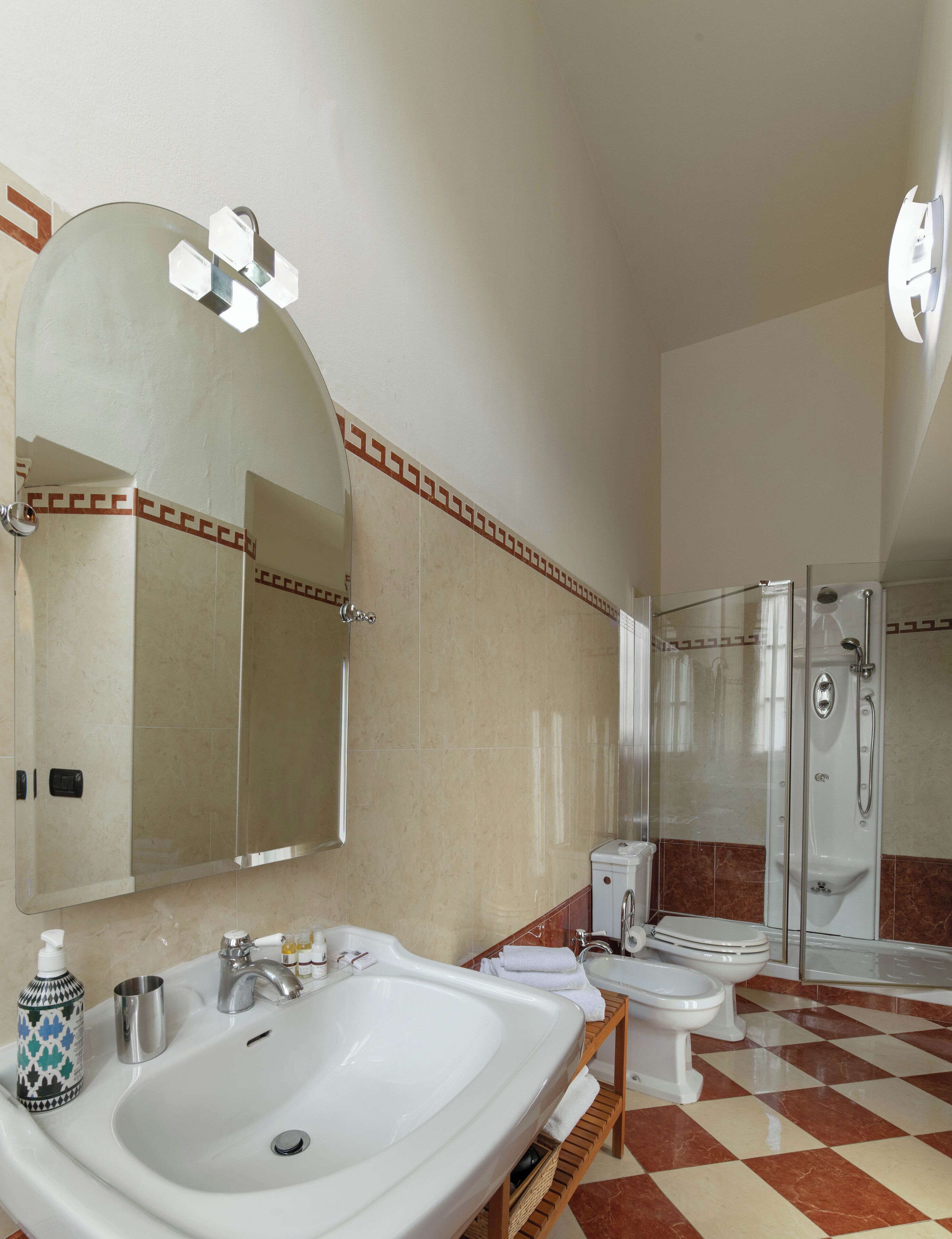 Ein Badezimmer mit einem großen Spiegel, einem Waschbecken, einer Toilette und einer Dusche.