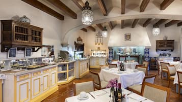 A restaurant with wooden beams, white walls, and tables set for dining.