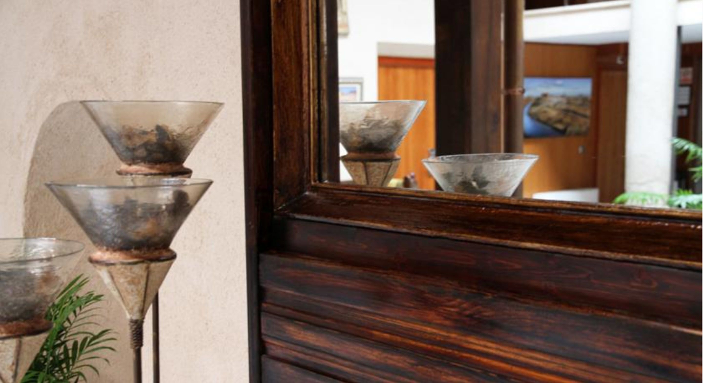 Una porta in legno con uno specchio che riflette tre oggetti di vetro.