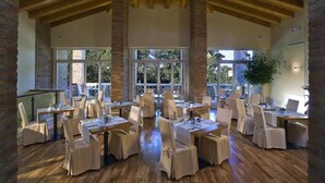 A spacious dining area with wooden beams, large windows, and tables set for dining. - Ca' Mura' Hotel (Masera di Padova)