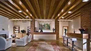 A spacious lobby with a reception desk, seating area, and a large rug. - Ca' Mura' Hotel (Masera di Padova)