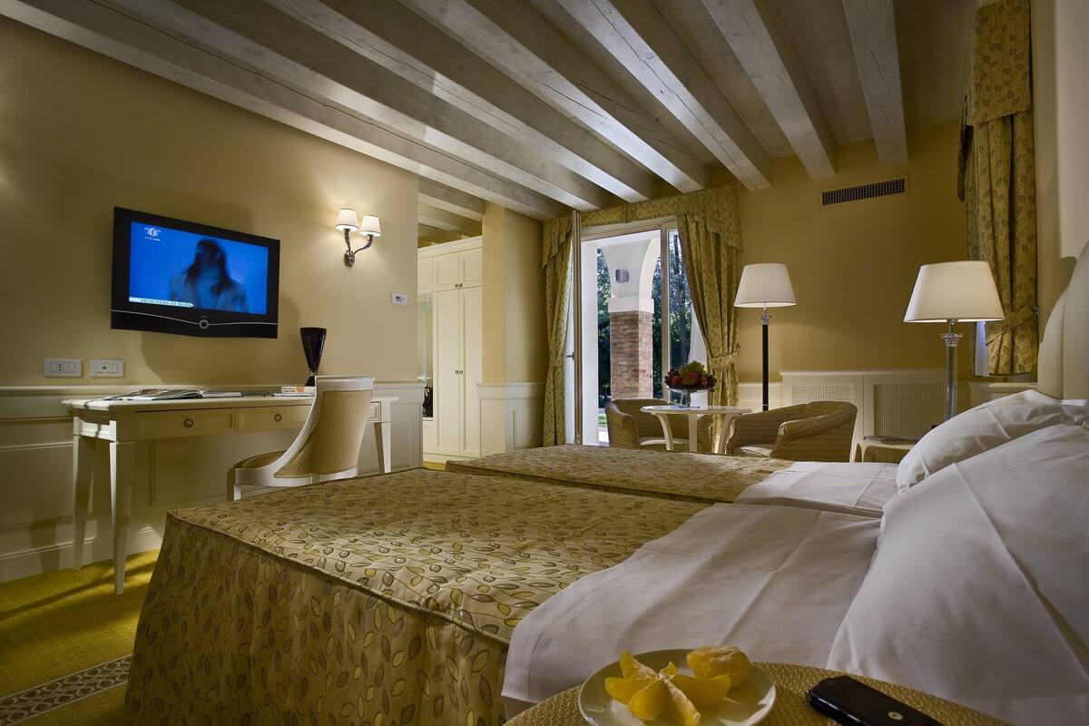 Una habitación de hotel con cama, escritorio, televisor y zona de comedor.