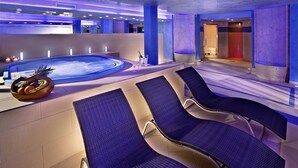 A modern indoor pool area with lounge chairs and a hot tub, featuring a minimalist design and ambient lighting. - Ca' Mura' Hotel (Masera di Padova)
