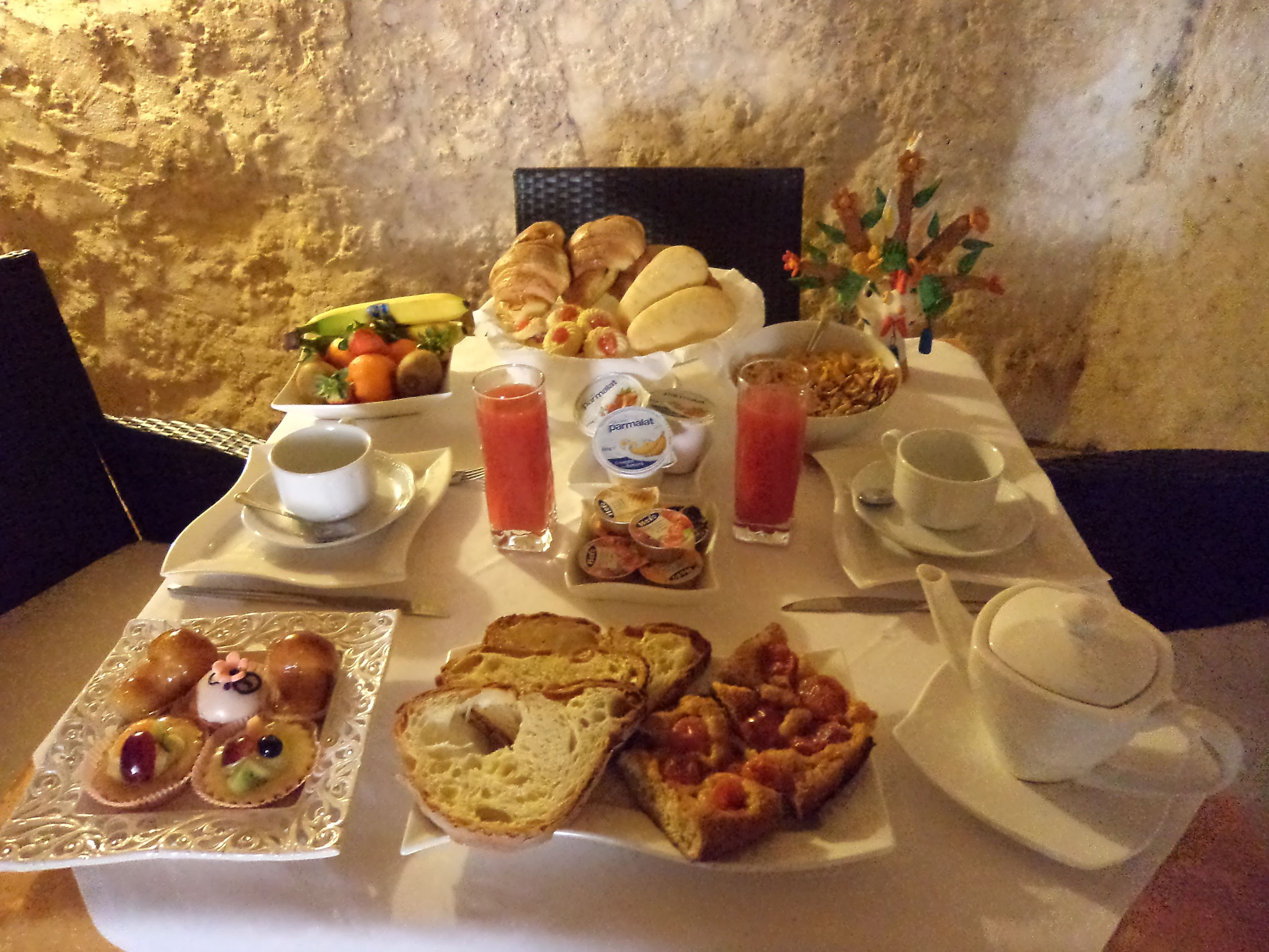 Un buffet de petit-déjeuner avec des viennoiseries, du pain et des fruits.