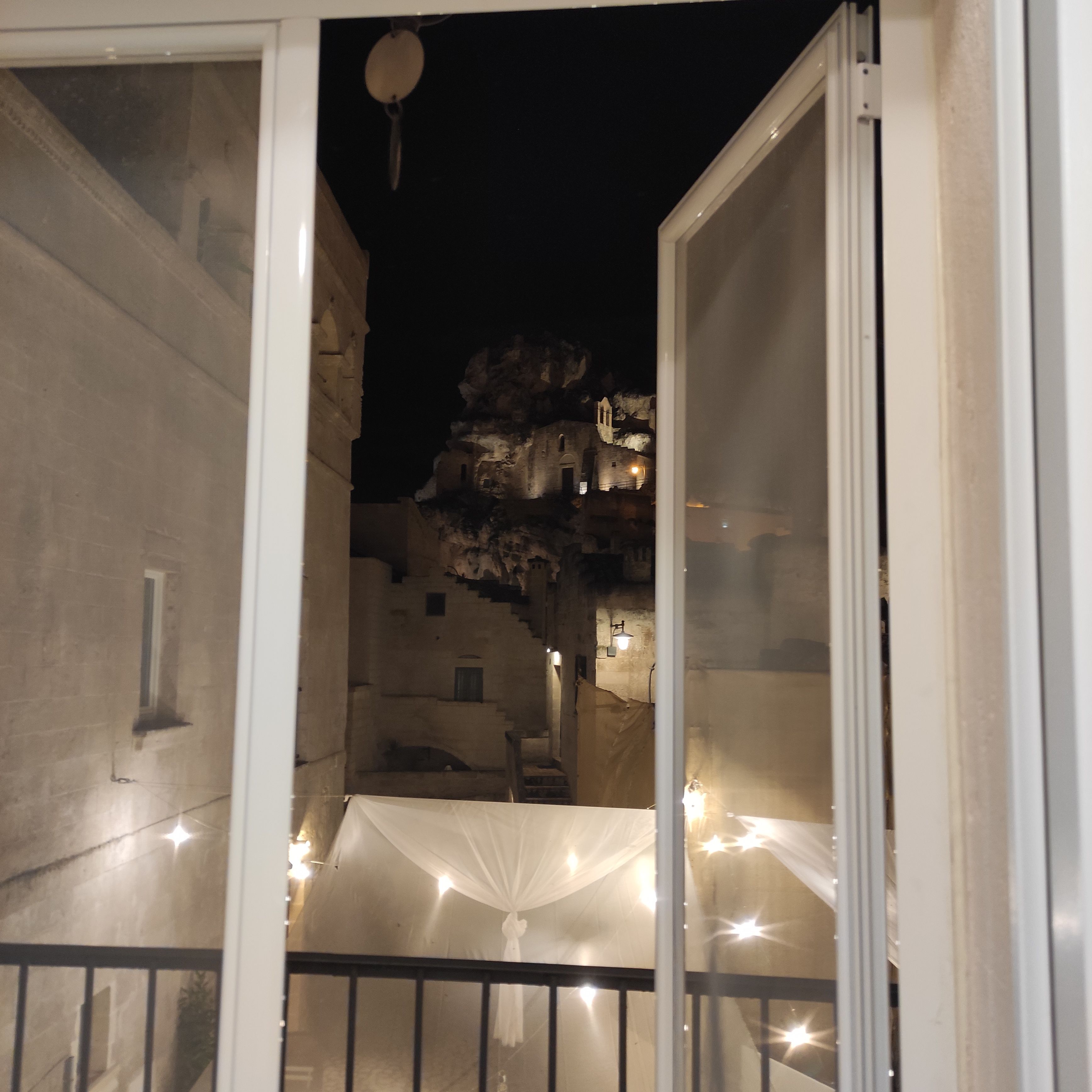 A balcony with a view of a historic building at night.