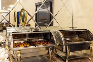 A buffet with various food items, a door, and wall decorations. - My Assos Hotel (Istanbul)