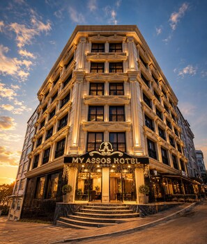 A multi-story hotel with a grand entrance, a prominent sign, and a staircase leading to the entrance. - My Assos Hotel (Istanbul)
