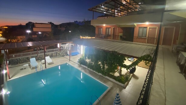 A rooftop pool with lounge chairs, a covered patio area, and a view of the surrounding buildings. - Beyaz Kale (Denizli)