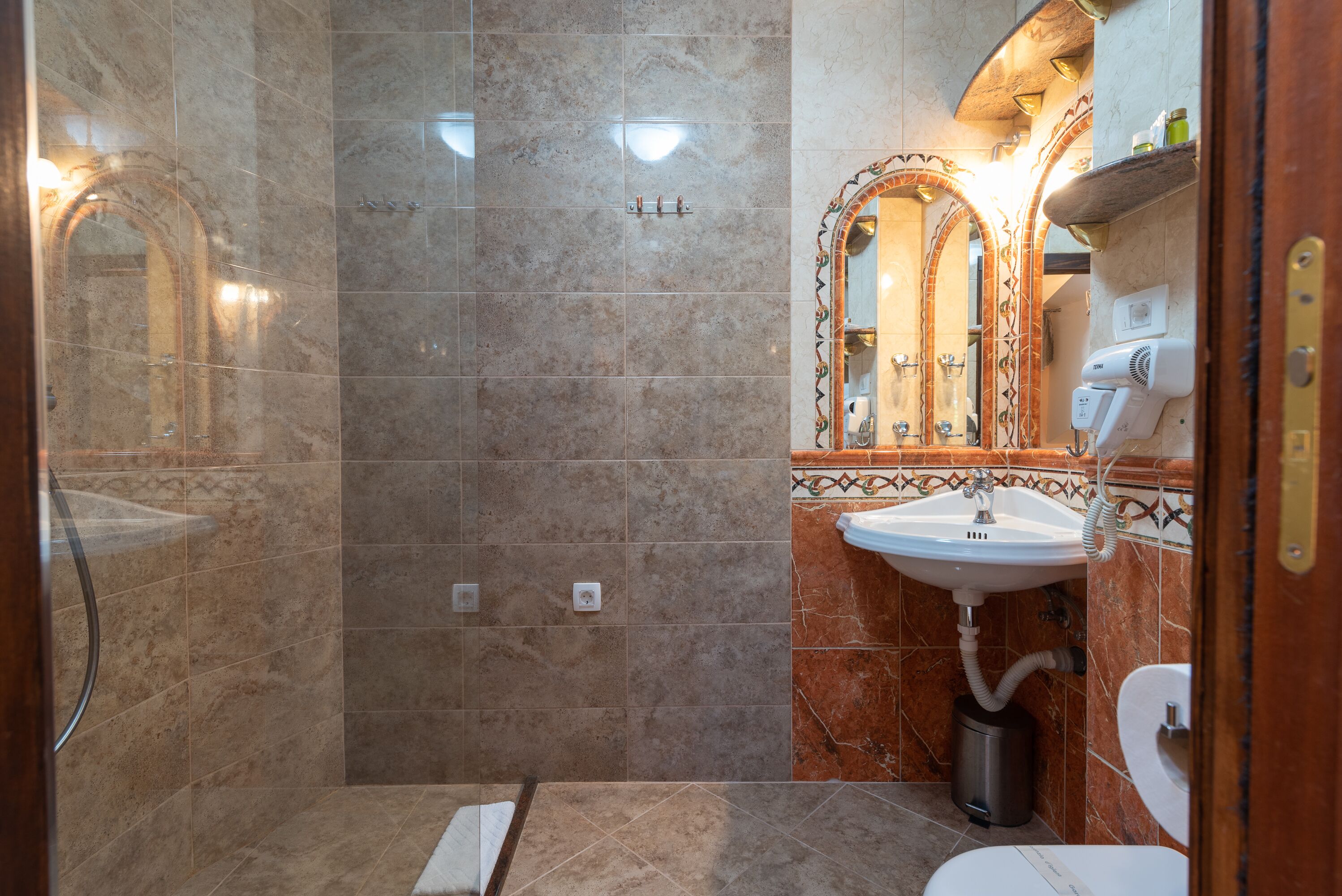 A bathroom with a shower, sink, and toilet.