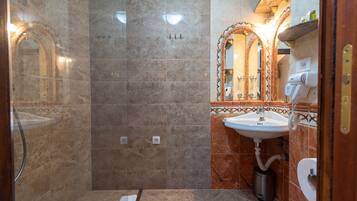 Un baño con ducha, lavabo e inodoro.