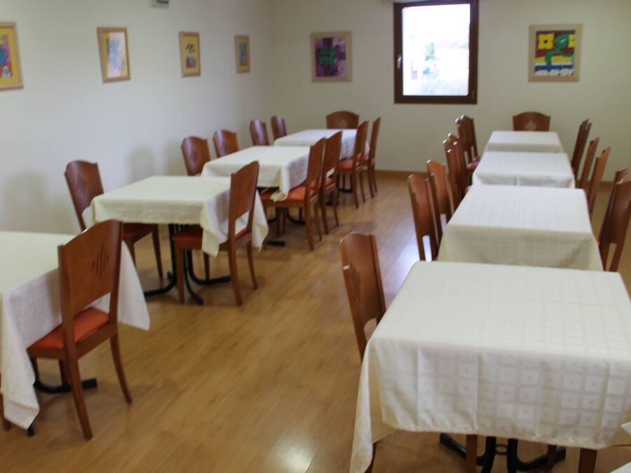 A dining area with multiple tables and chairs, arranged in rows.