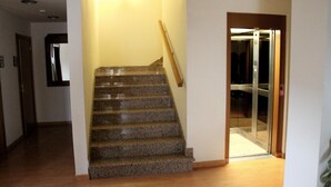 A staircase with a wooden handrail leading to a glass door entrance. - Agorreta (Galar)