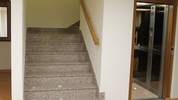 A staircase with granite steps leading to an elevator.