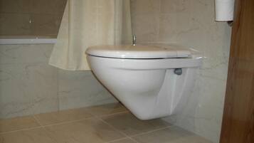Un baño con inodoro, bañera y cortina de ducha.
