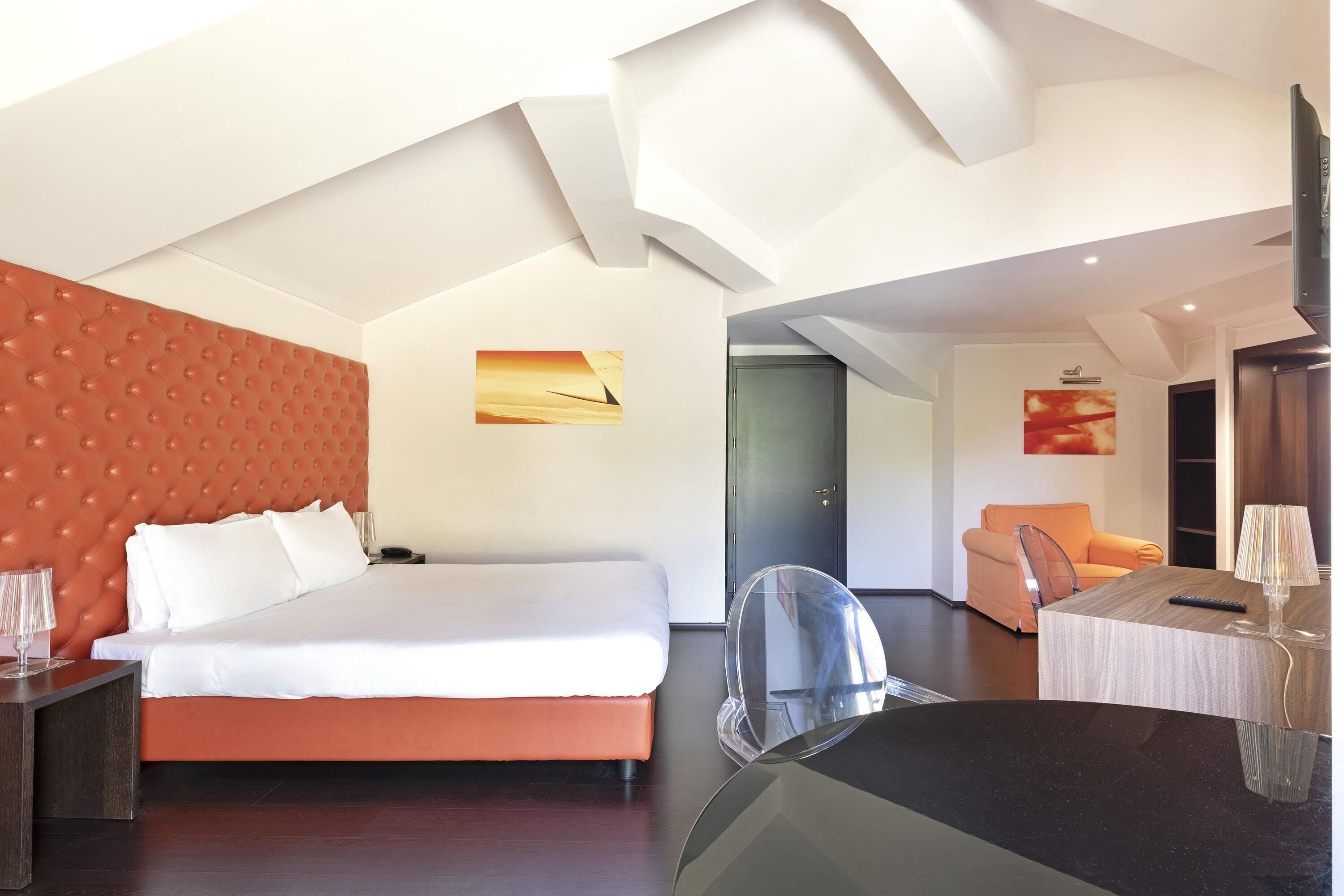 Una habitación de hotel moderna con una cama grande, un escritorio y una silla.