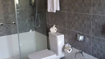 Une salle de bain moderne dotée d’une douche à parois de verre, de toilettes, d’un bidet et d’une baignoire.