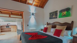 A hotel room with a bed, a nightstand, a wooden headboard, a painting, and a ceiling light. - Hotel Rural Casablanca (Los Realejos)