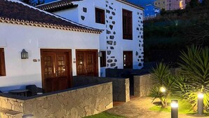A white building with stone accents, a tiled roof, and a stone wall. - Hotel Rural Casablanca (Los Realejos)